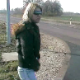 A woman takes a huge dump on the side of a busy roadway.